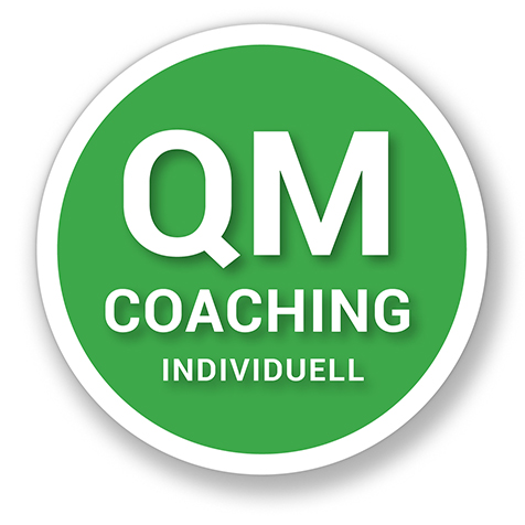 Grafisches Element, grüner Button mit weißem Schriftzug „QM Coaching".